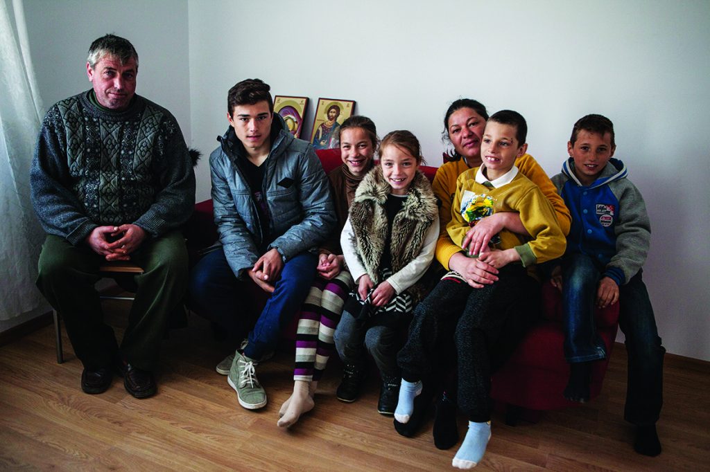 Paul sitting on a sofa with his brothers and sisters and his parents