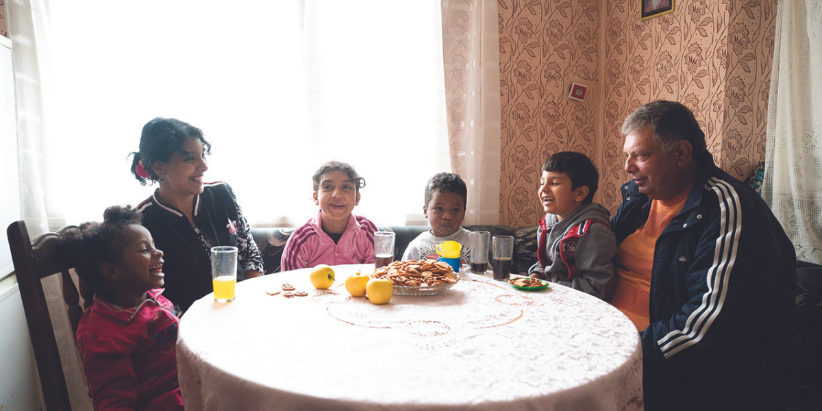 Kaloyan and Maria sitting with their parents and siblings at their kitchen table. Finally, they can spend their childhood where they belong - with their family.